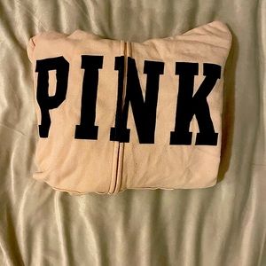 Light pink hoodie with orange and blue stripes on bottom sleeve.